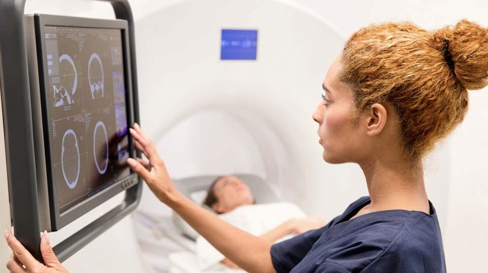 Doctor examining brain scan with advanced medical technology, representing well-equipped practices