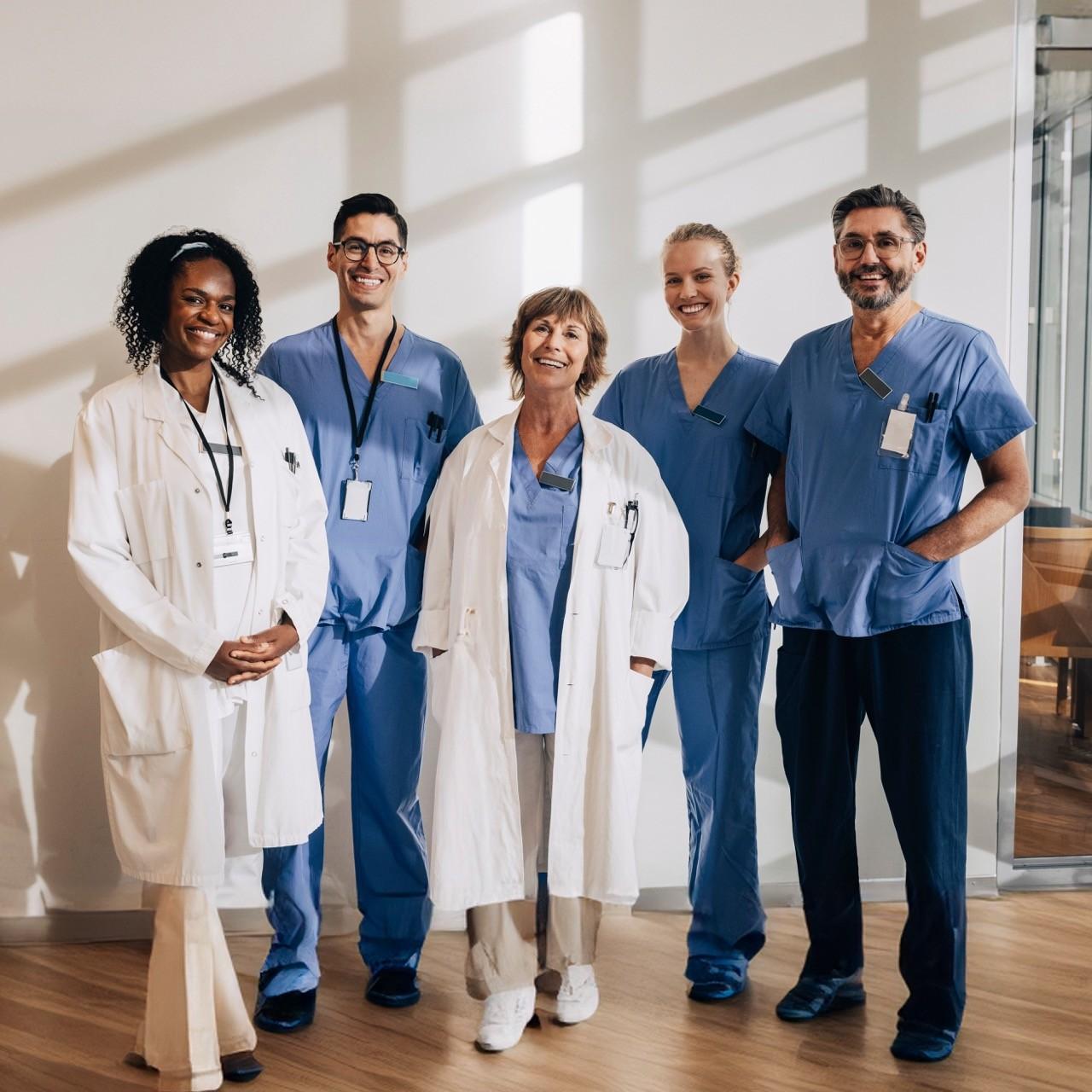 Diverse group of hospital staff members standing together, representing the collaborative network of care